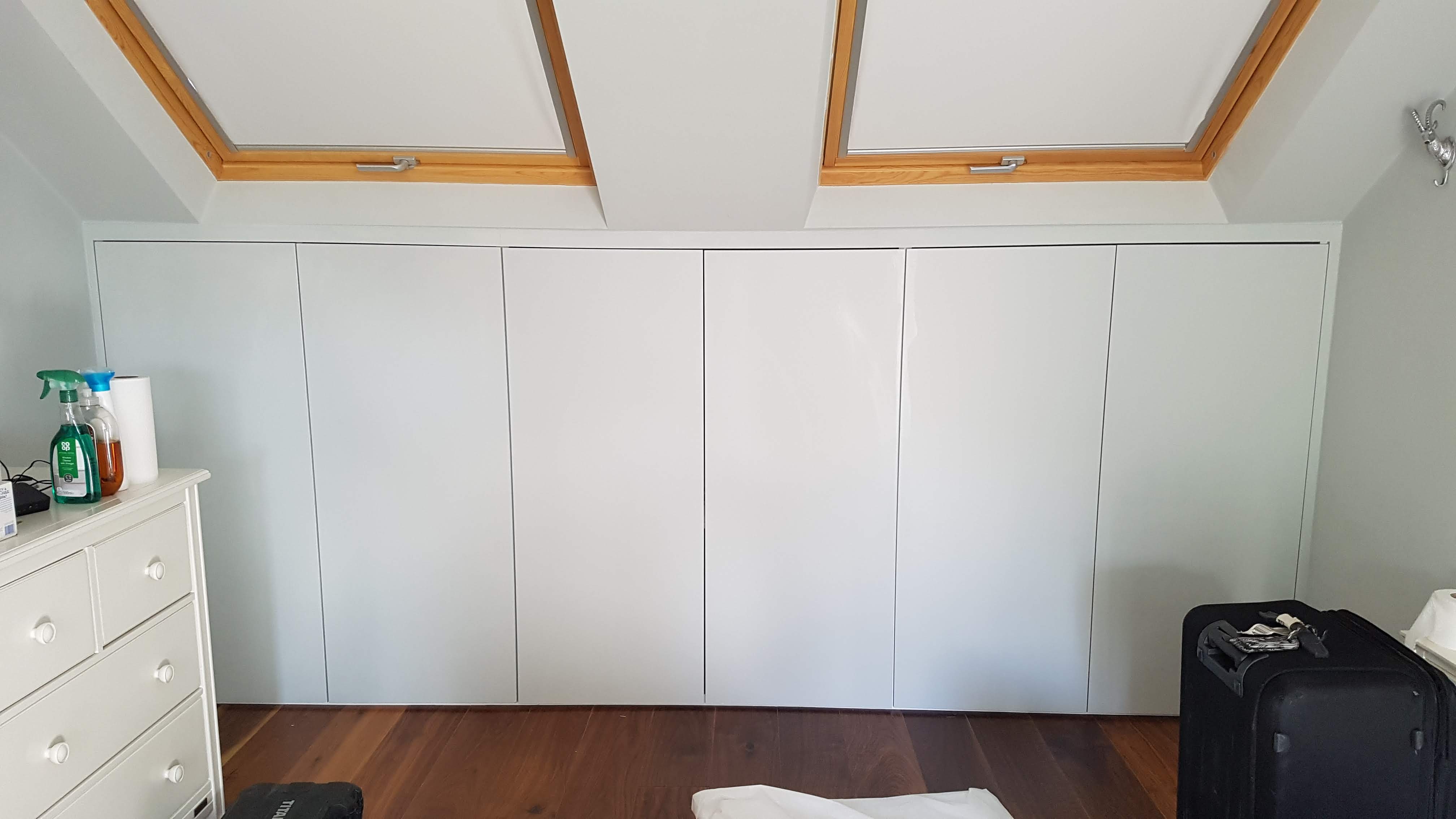 Minimalist Grey Steel fitted wardrobe with handleless doors, perfectly integrating with sloped ceilings
