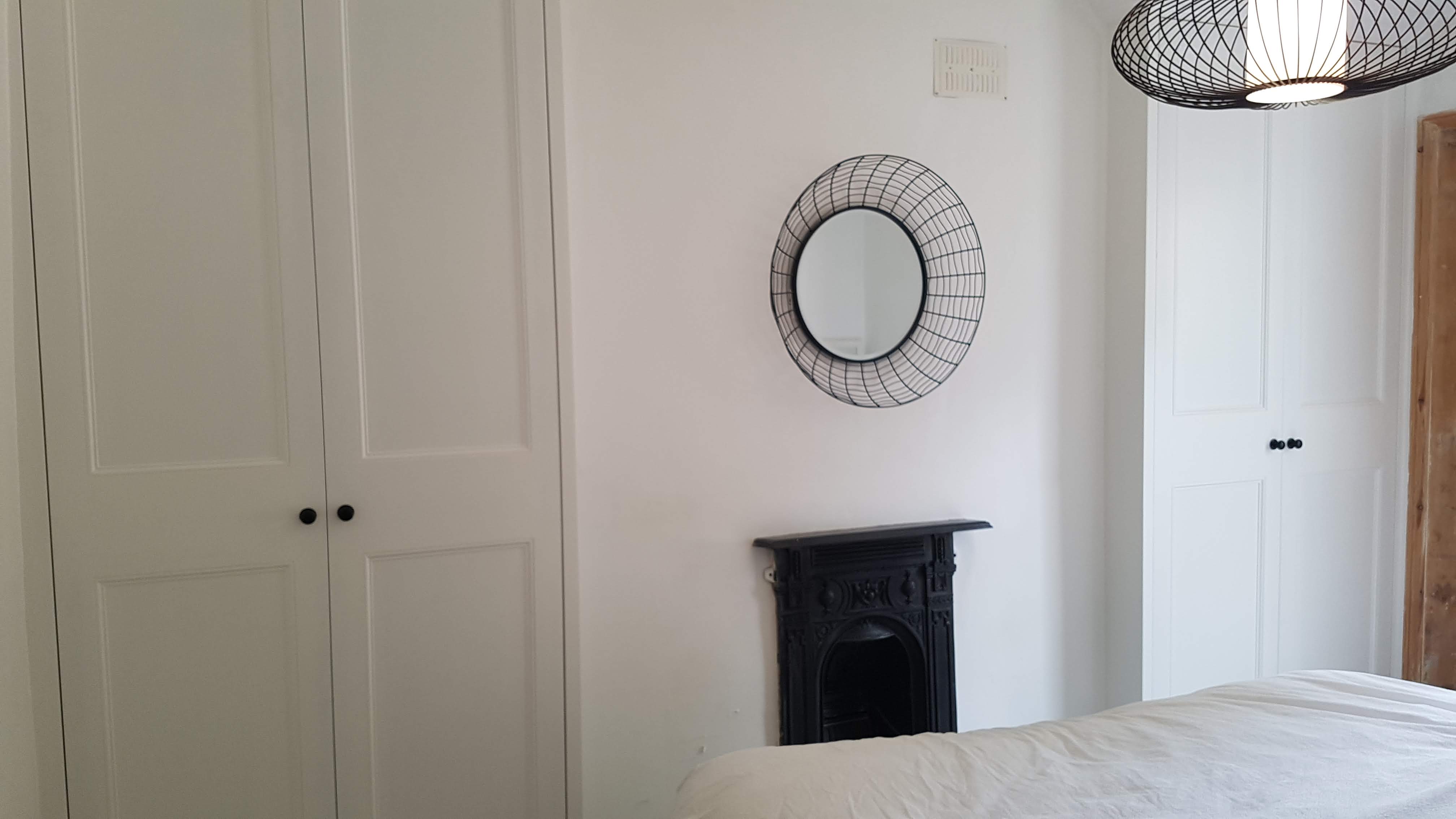 Fitted wardrobe in Shaded White Farrow and Ball paint, traditional shaker style with black knobs