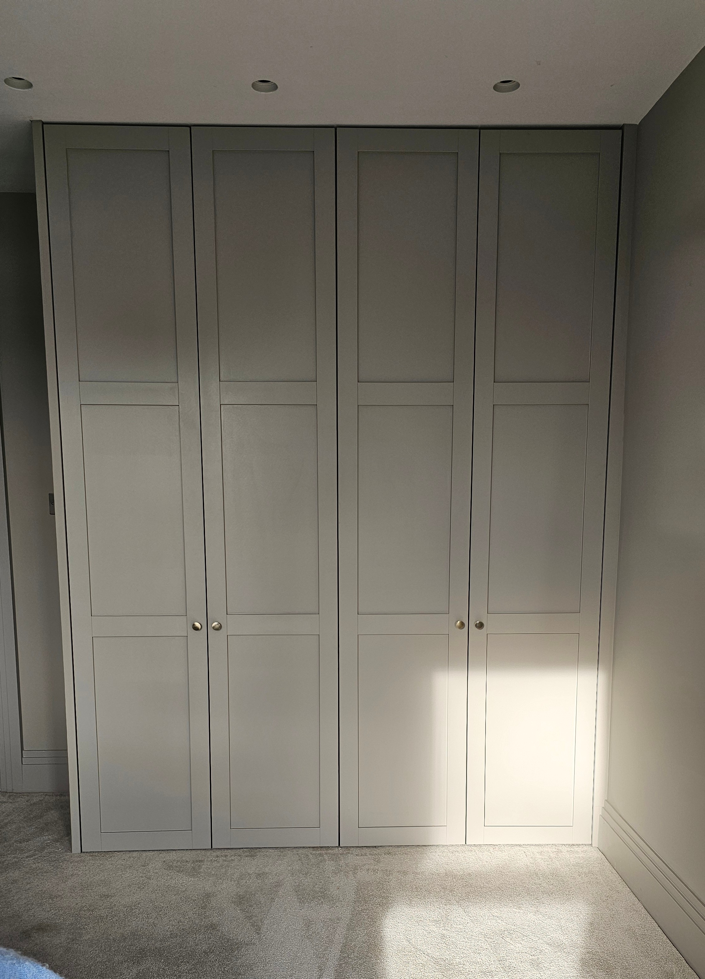 Fitted Shaker wardrobe in Skimming Stone by Farrow and Ball with brass knobs